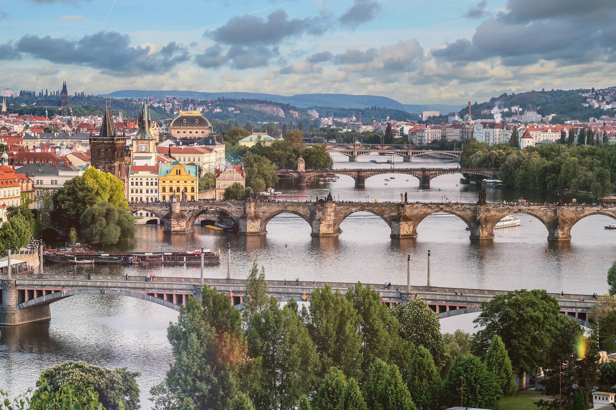 Explore the breathtaking urban landscape of Prague featuring the iconic Charles Bridge over the Vltava River.